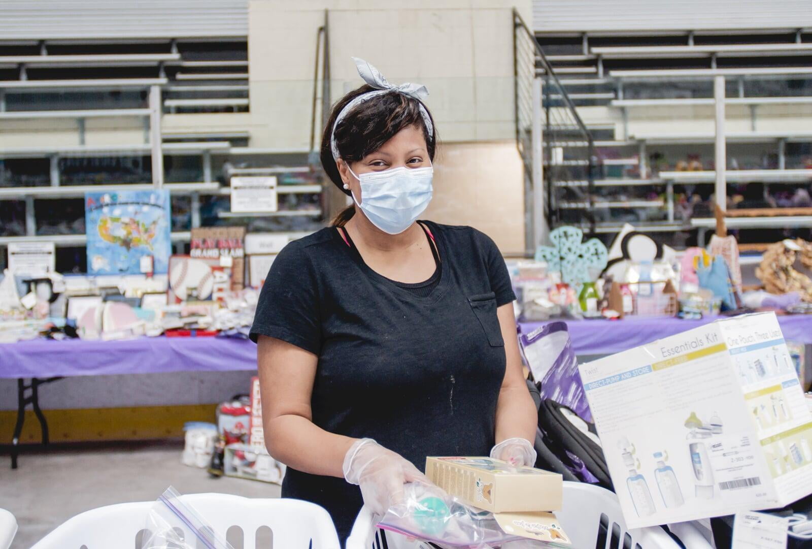 A masked Team Member with gloves helps out at a local JBF sale.
